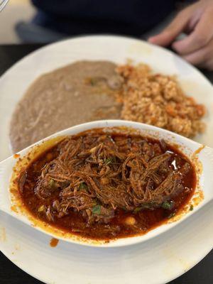 Birria, plate. It's paired with red rice, beans and tortillas