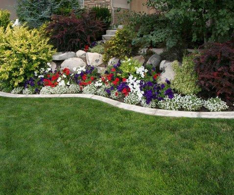 Turf and planter with rocks and flowers