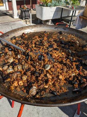 Giant vat of paella being prepared outside of the store