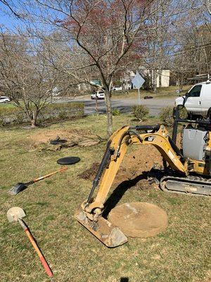 Excavations of buried septic tank and overflow cesspool, installing collars and steel manhole covers at grade for service now and future