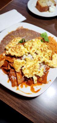 Red chilaquiles w scrambled eggs, beans & rice. SO GOOD