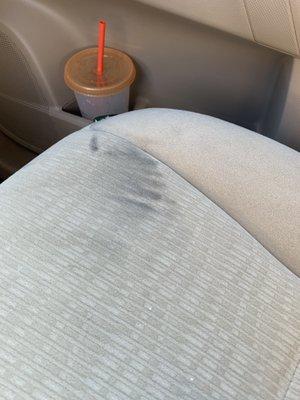 Clearly an oily handprint on beige colored car seat.