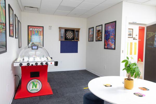 Game room with bubble hockey, darts, and retro game posters