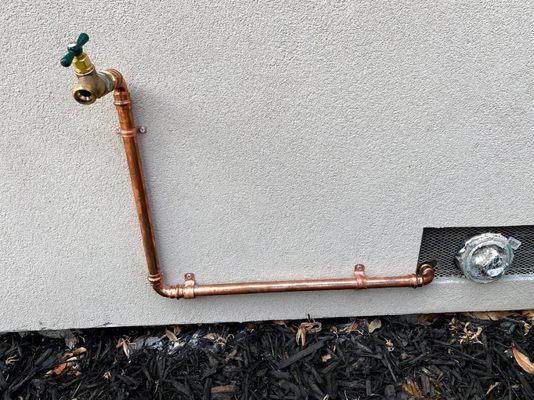 Installing a faucet at the side of the house.