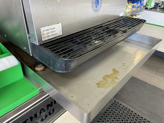 A drip pan that is cleaned so infrequently that soda has completely evaporated. This was at 11:30 AM.