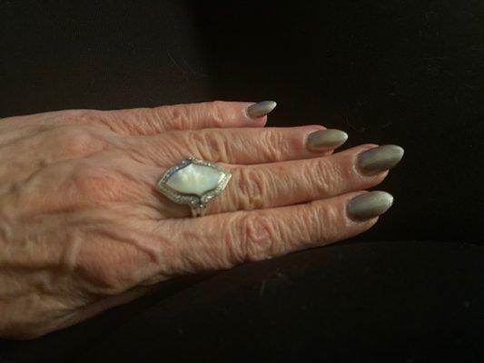 Mother of pearl ring with diamonds in a white gold setting.