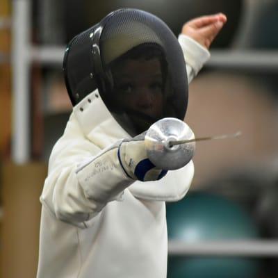 A young fencer focused in combat!