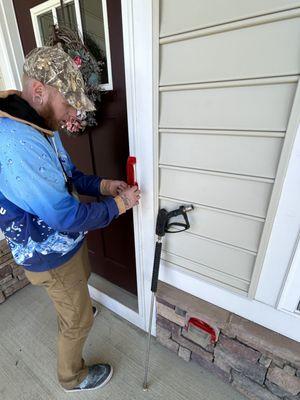 Electrical outlet and doorbell getting cover to stop water from damaging them prior to soft wash on the Lake Ridge, VA home.