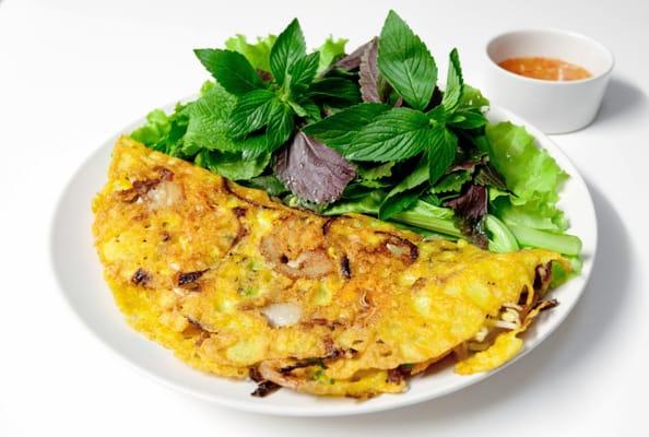 Vietnamese crepe, or banh xeo, is filled with nutritious vegetables and served with fresh herbs. Crunchy, delicious and healthy savory crepe