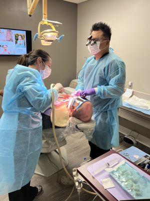 Dr. Loc Tong and Natalie (Chairside Assistant) performing a surgery.