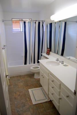 Large bathroom with long countertop and plenty of storage.