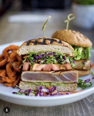 Wicked Tuna Burger. 5oz Seared Ahi, Coconut Amino, Asian Coleslaw, Tomato, Avocado Dressing. Served with Roasted Sweet Potato Fries