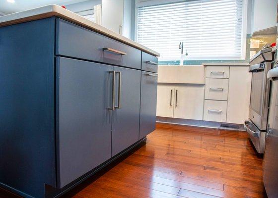 Modern kitchen with blue vanity for island and hardwood floor design and installed by Aladdin carpet and Floors