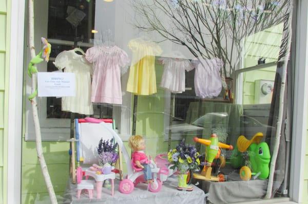 spring front window showing smocked dresses and some toys