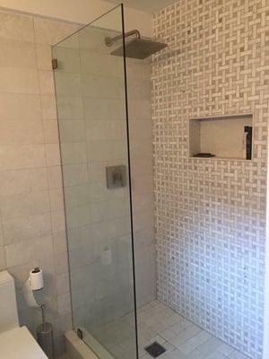 Walk in shower with accent wall - marble mosaic with a niche made out of high grade porcelain and subway tile porcelain tile throughout