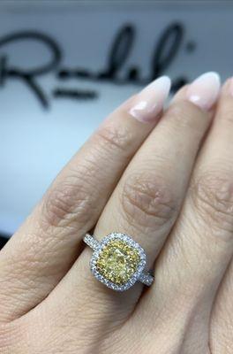 Yellow diamond surrounded by one halo of yellow diamonds and one halo of white diamonds with a white diamond band