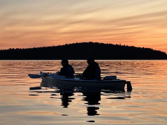 Friends in their kayak pausing for a stunning sunset