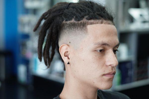 Fade with dreadlock manbun look.