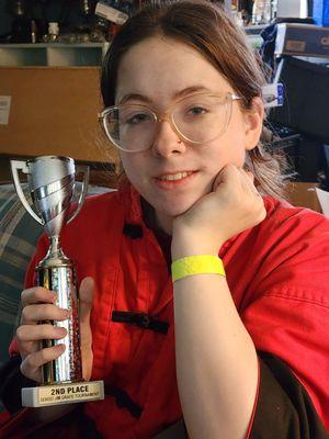 Granddaughter winning a trophy at a martial arts tournament representing Rochester Kung Fu and Fitness.