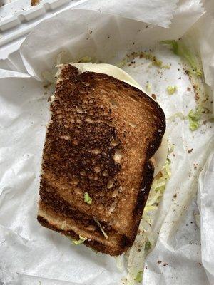 Burnt turkey sandwich. Why serve this? Plus it was supposed to have bacon. Two measly slices.