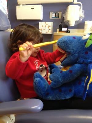 My daughter brushing the dinosaur's teeth.