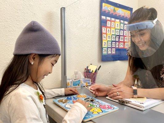 Speech therapy with a plexiglass barrier and face shield when the client needs to see the therapist's mouth for articulation.