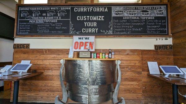 Ordering kiosks and menu as of 5/24/23. Yes, this is their entire space minus two chairs and a vintage motorcycle.