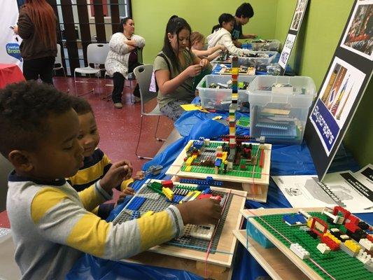 LEGO Day celebration! Kids engaged in building LEGO skyscrapers on a earthquake table.