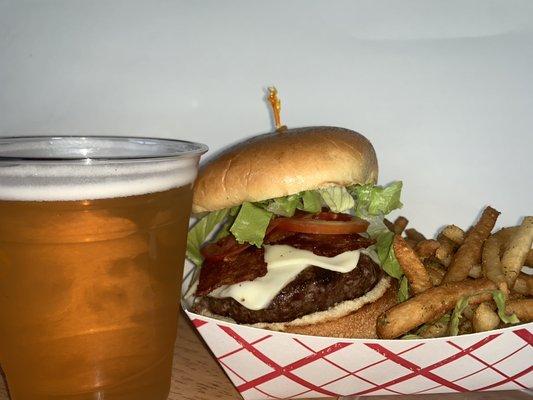 Bacon Cheeseburger served on a brioche bun with Lettuce, tomato, and a pickle spear. Also a side of fries.