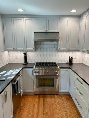 Sleek and sophisticated: A modern kitchen with timeless grey shaker cabinets and sleek black countertops.