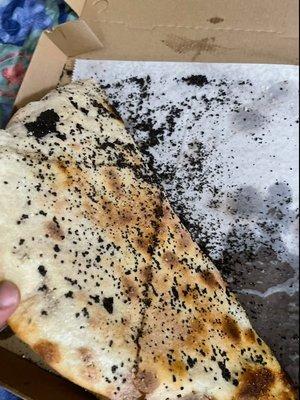 Black substance all over bottom of my pizza