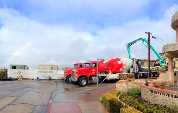 Trucks backed up to CPI's boom at a large mat slab pour in Corona Del Mar.