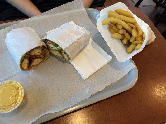 Buffalo chicken wrap with a side of fries.