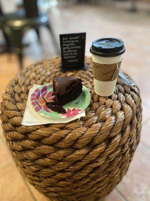 Chocolate cake, loose leave black tea,and a cute inspirational quote on a cozy two seater in the corner.