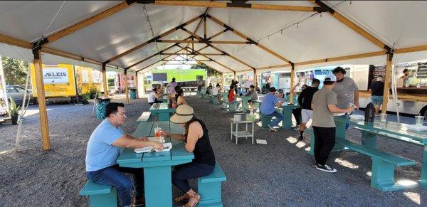 This is the better food truck park because there are lots of tables under this tent to provide shelter from the hot sun.