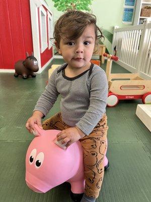 My grandson riding the pig.