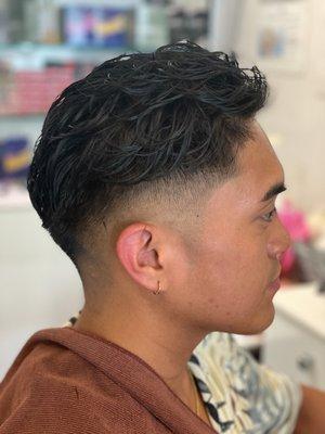 Low-mid skin fade. Permed top.