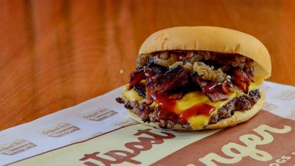 BBQ Bacon Smash Burger with BBQ sauce, bacon, American cheese, pickles, caramelized onion.