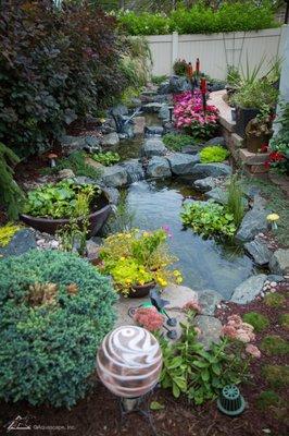 Backyard pond with flowing stream and waterfall