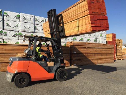 Forklift loading framing lumber on to customer's flat bed trailer at Dixieline National City production lumberyard.