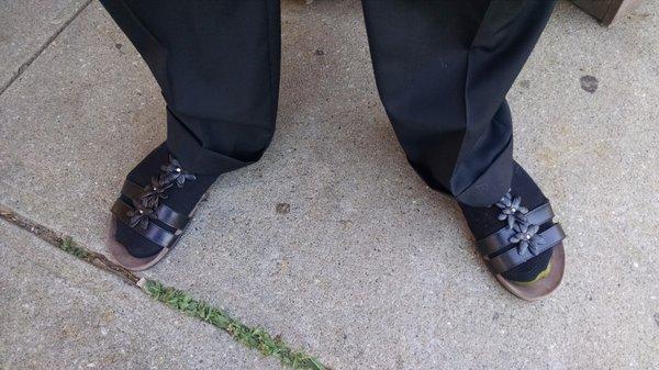 My husband with half of his feet in our daughter's sandals.