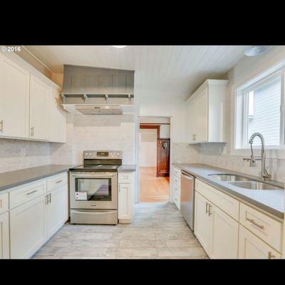 Remodeled kitchen shaker cabinets ss appl.quartz counters marble subway backsplash wood look tile floor