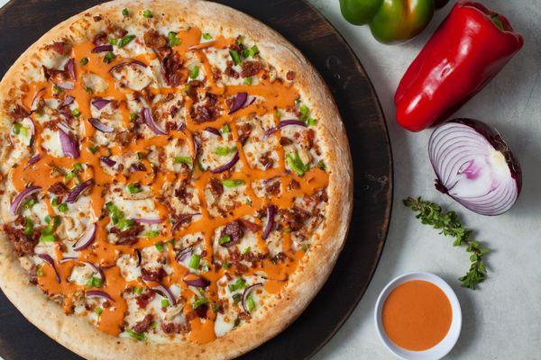 Buffalo Chicken Pizza, made with fresh dough, ranch Sauce, cheese, chicken, bacon, bell pepper, onion & drizzle of buffalo sauce on top