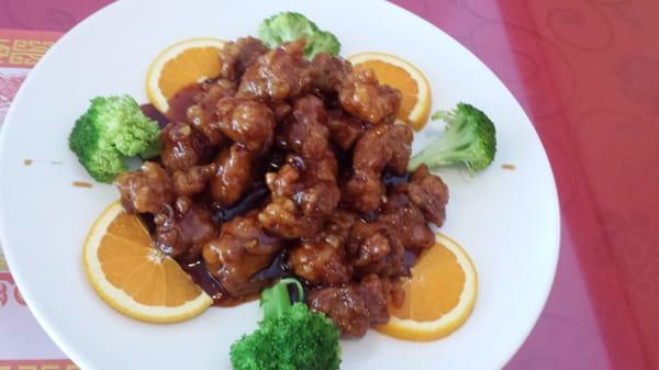 Large General Tso's Chicken complemented with fresh orange slices and broccoli.