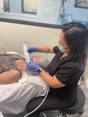 Our certified ultrasound technician performing Ultherapy on a client.