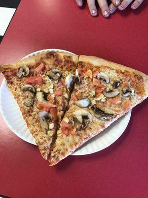 Two slices of pizza with garlic, mushrooms and fresh tomatoes