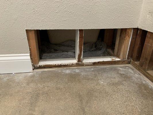 Bathtub leak, causing damage on adjacent wall.