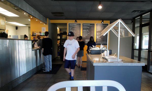 Menu on the blackboard,order station/cashier and food preparation area.