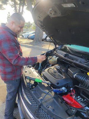 Mechanic showing me the coolant in the engine and Issac lied about its condition.