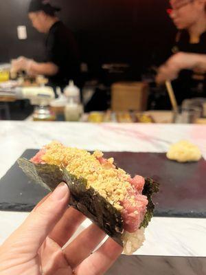 A unique tuna hand roll with crushed peanuts